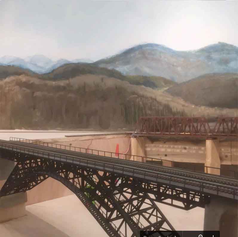 model train bridge with mountain backdrop